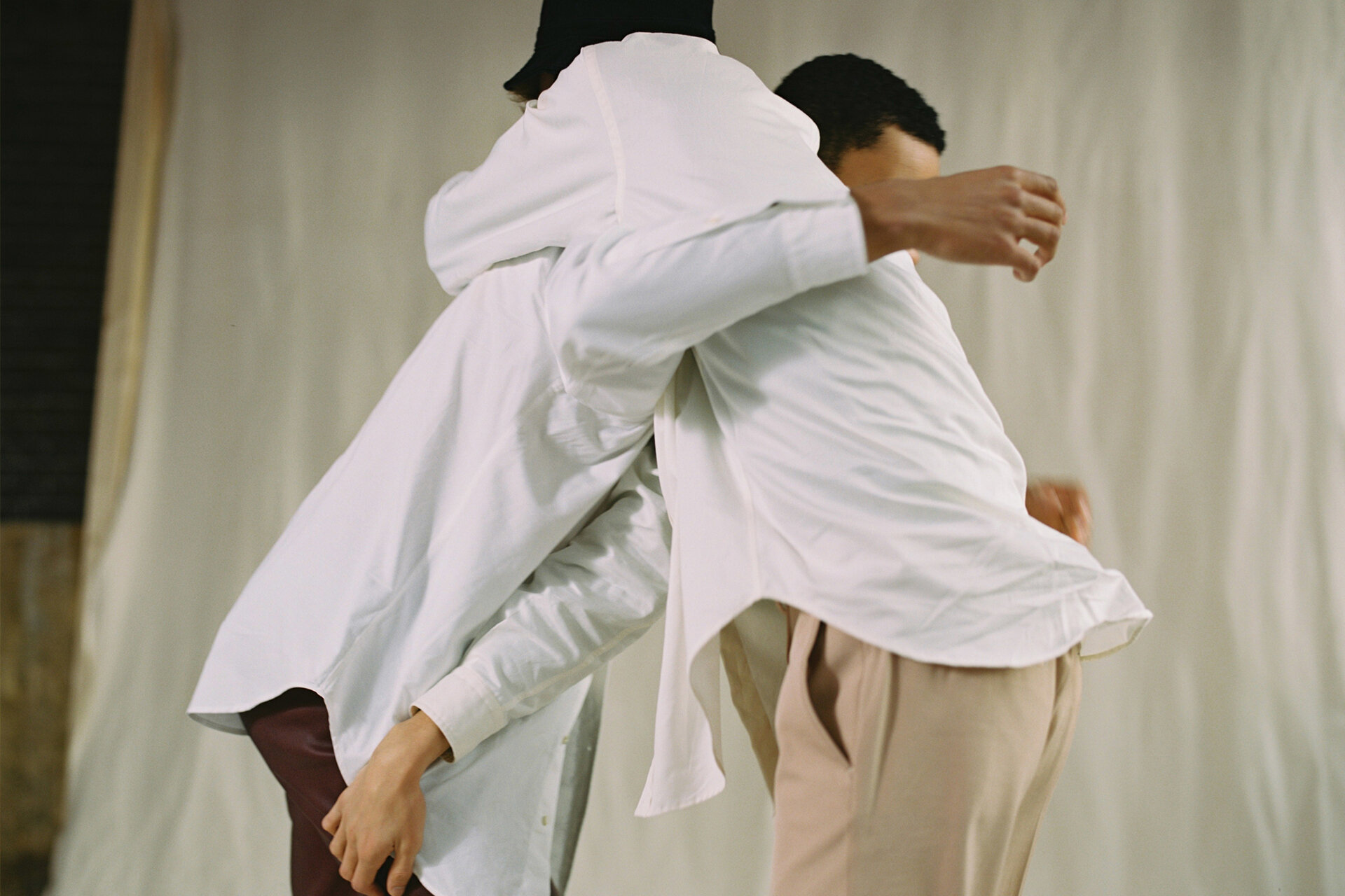 Zwei Männer in weißen Hemden liegen sich in den Armen und greifen sich gegenseitig über die Schulter