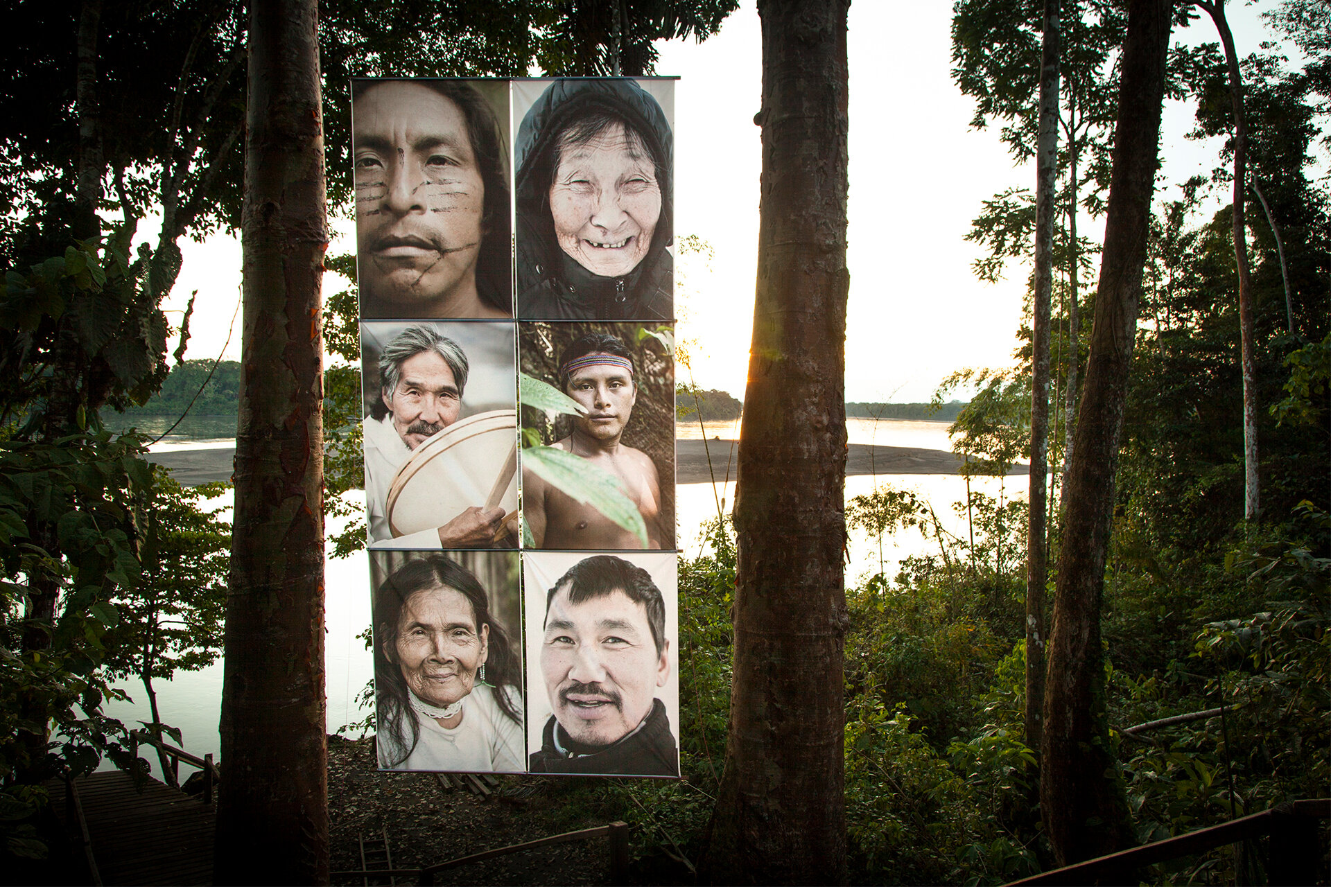 Fotocollage: Sechs Portraits indigener Menschen arrangiert auf einer Landschaftsaufnahme mit Blick durch urwaldähnlich wachsende Bäume auf eine Wassermündung.