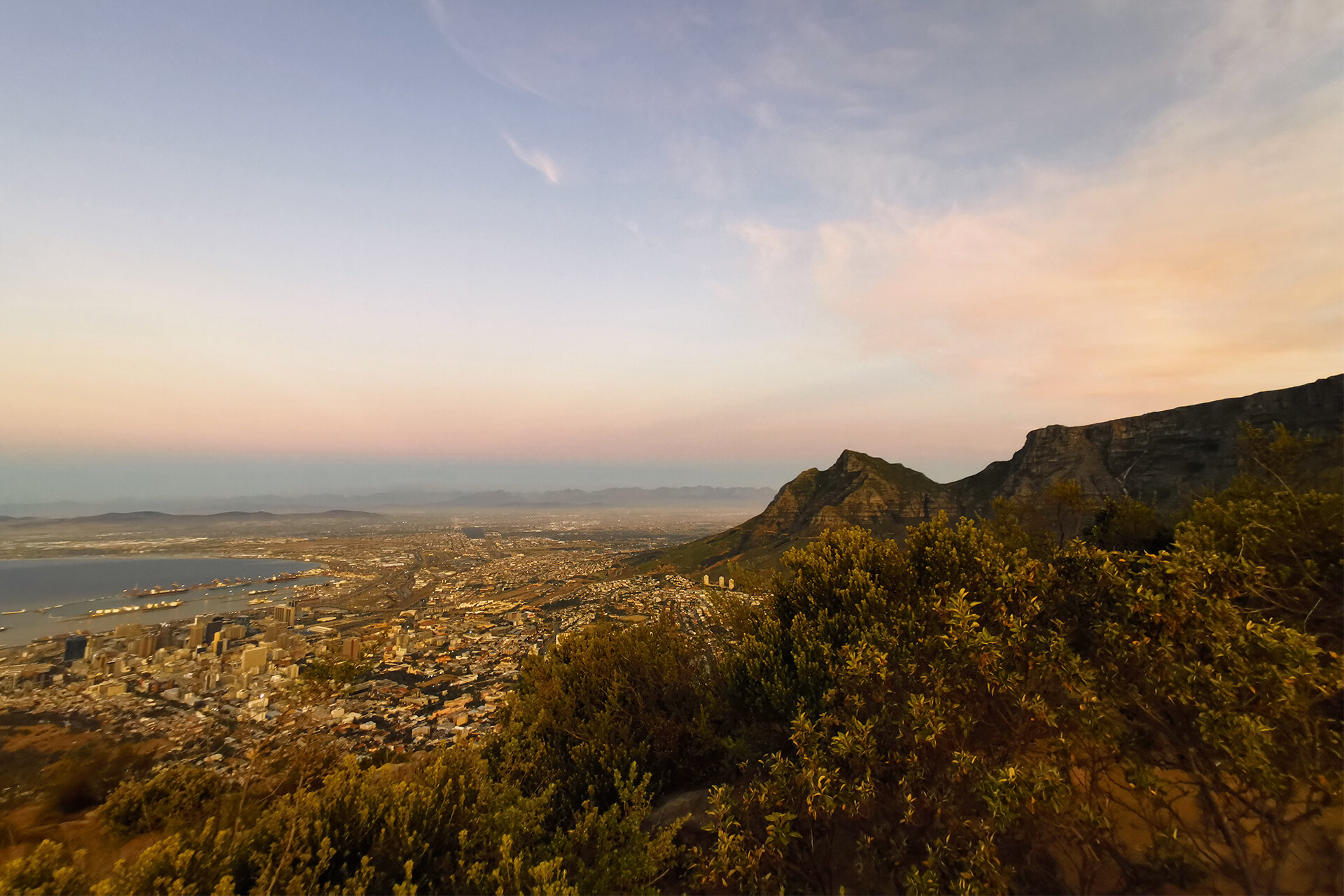Blick auf Kapstadt. Eine Küstenstadt mit Bergpanorama in der Dämmerung.