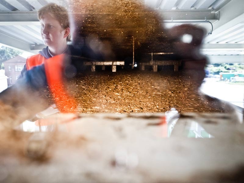 Das Innenleben eines Fermenters durch ein Sichtfenster: Blubbernde, braune Masse aus Bioabfall.